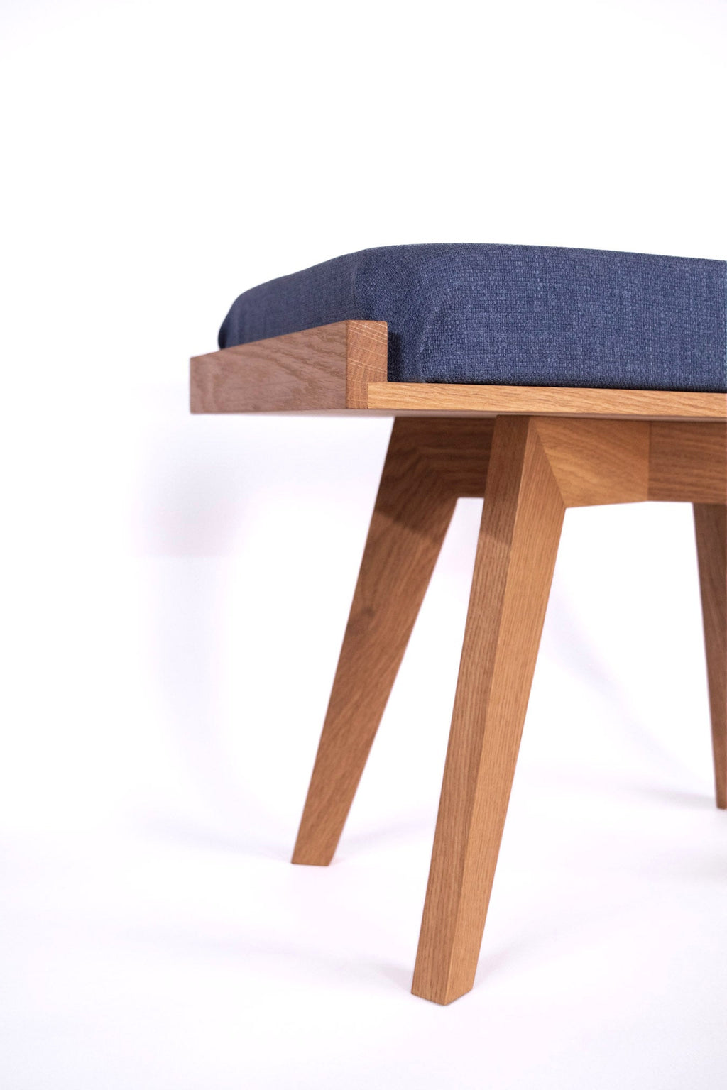 Wooden bench with a blue cushion on a white background